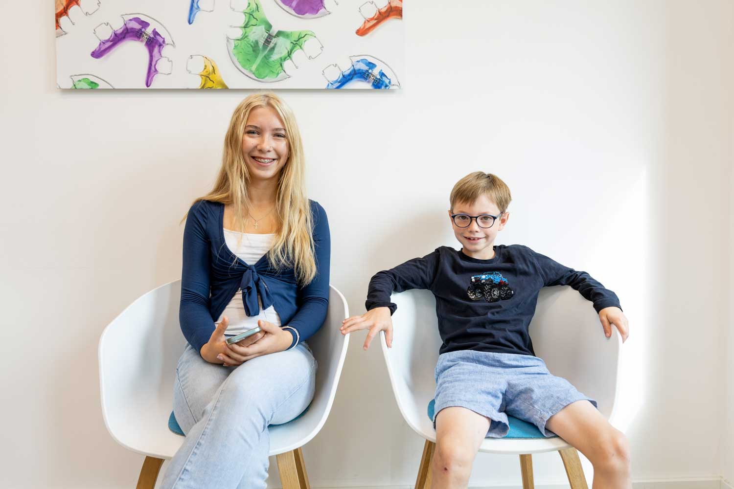 Alternativtext (Alt-Text) Junge Patientin mit fester Zahnspange und ein Junge im modernen Wartebereich der Kieferorthopädie Seelscheid in Neunkirchen-Seelscheid.