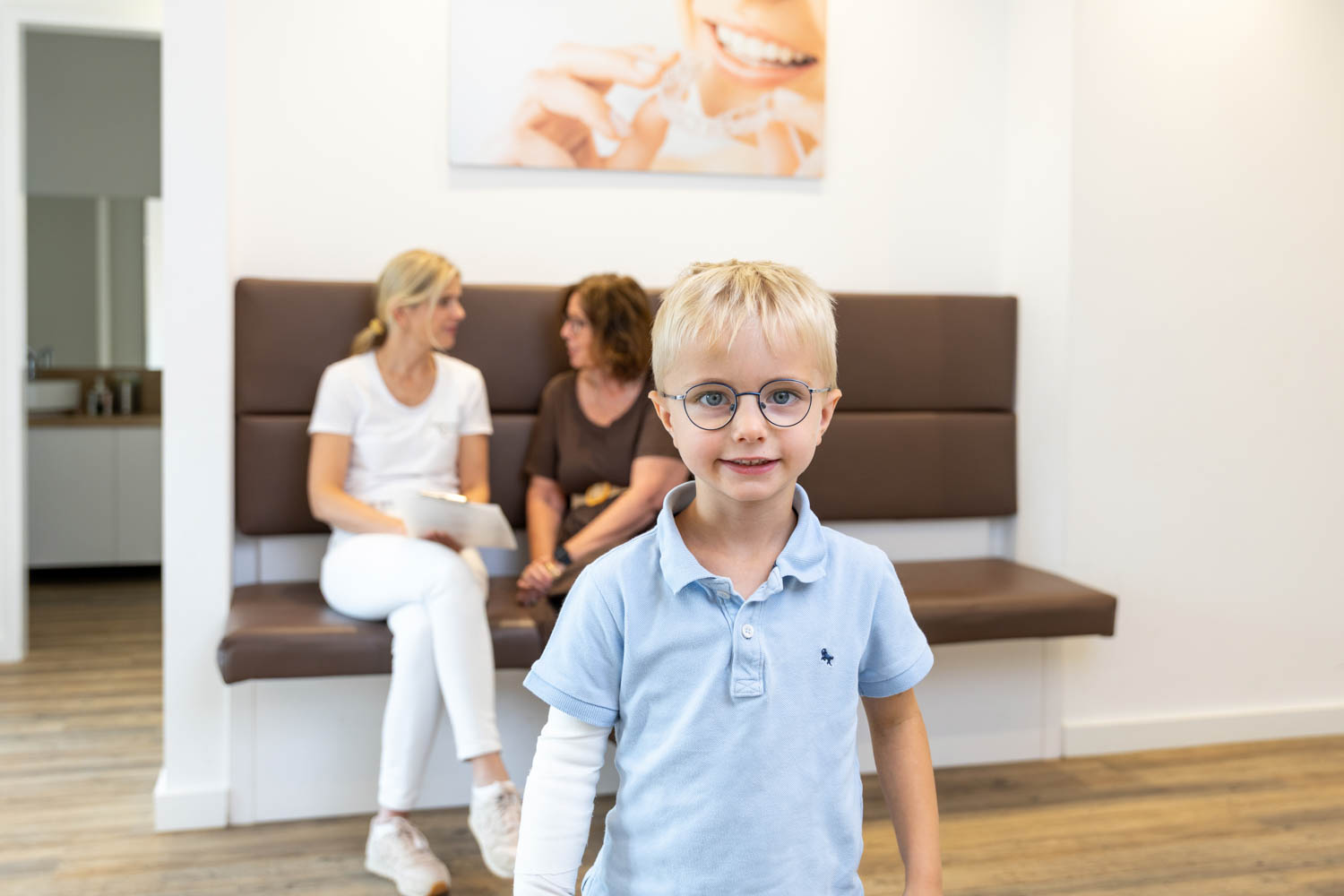 Kleiner Junge mit Brille im modernen Wartezimmer der Kieferorthopädie Seelscheid in Neunkirchen-Seelscheid.
