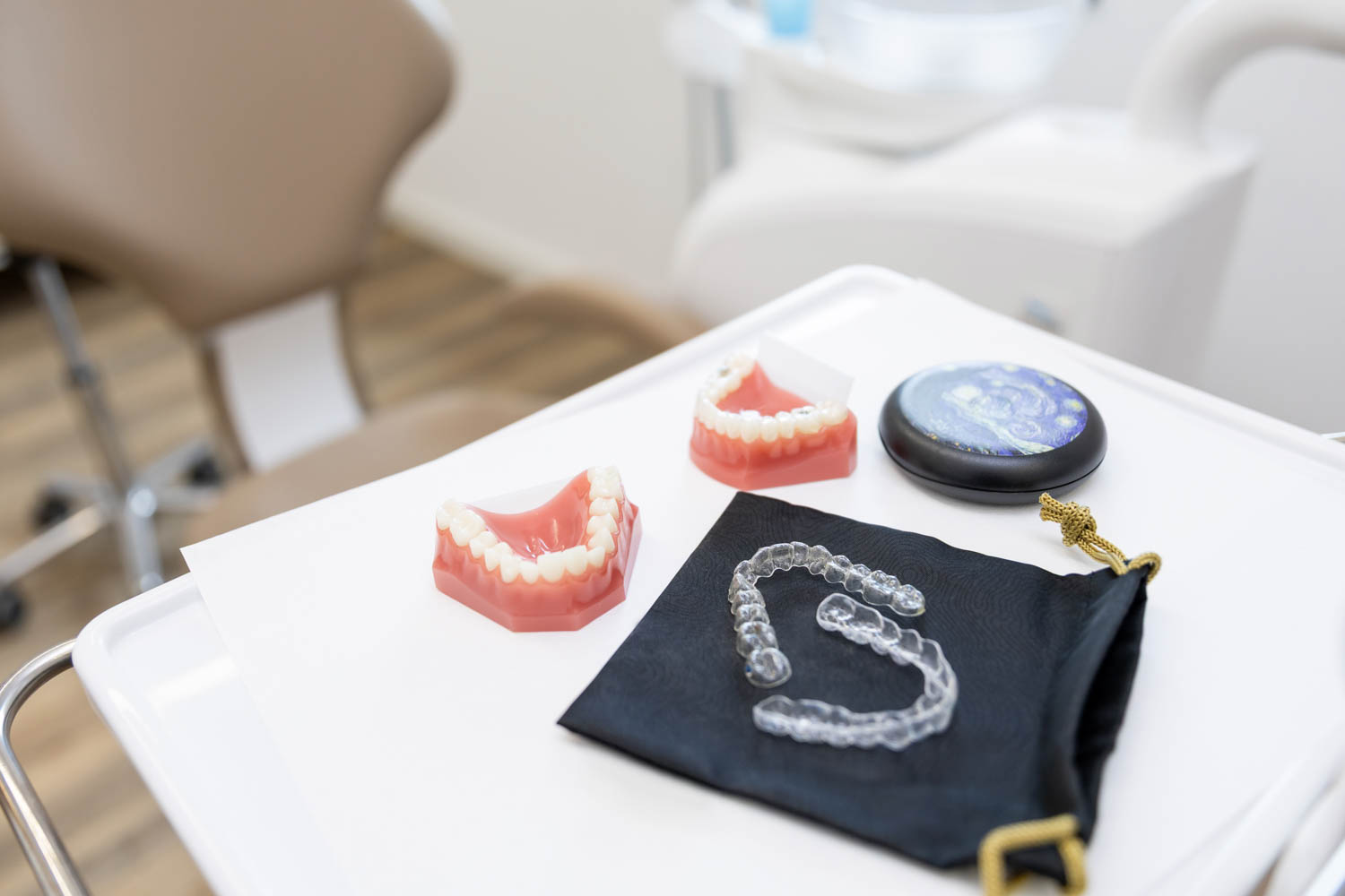 Transparente Invisalign Aligner Zahnschienen und Kiefermodelle auf einem Behandlungstisch der Kieferorthopädie Seelscheid in Neunkirchen-Seelscheid.