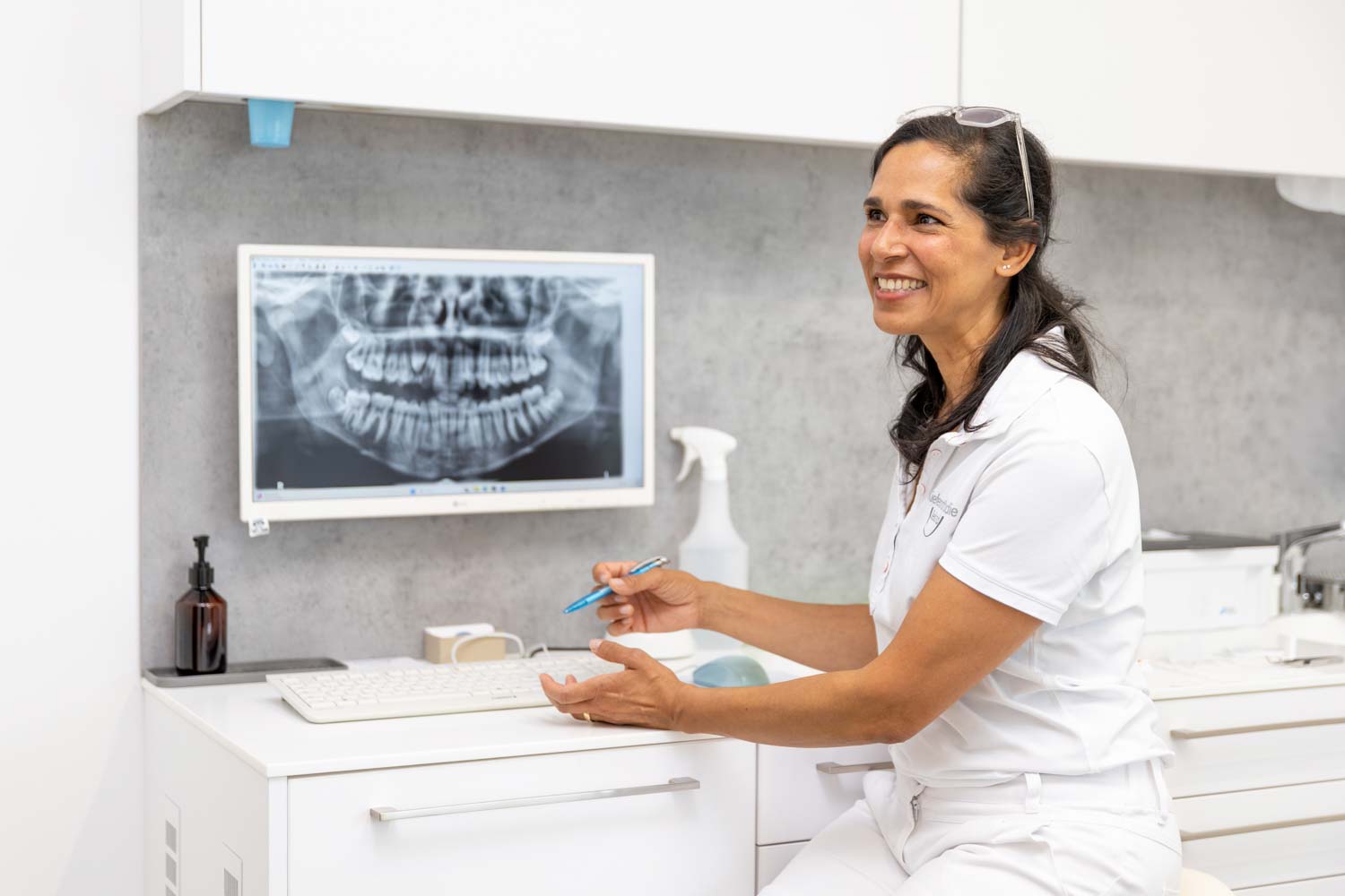 Kieferorthopädin Dr. Garcia erklärt ein digitales Panoramaröntgenbild (OPG) im Behandlungszimmer der Kieferorthopädie Seelscheid in Neunkirchen-Seelscheid.